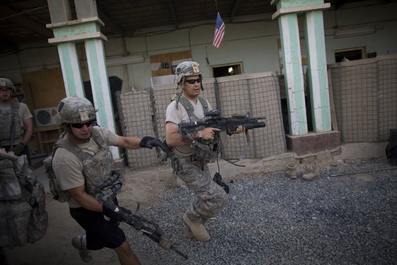 US soldiers from 1-320th Alpha Battery, 2nd Brigade of the 101st Airborne Division, run to firing positions after coming under attack by Taliban insurgents at COP Nolen, in the volatile Arghandab Valley, Kandahar, Afghanistan, Tuesday, July 27, 2010. 