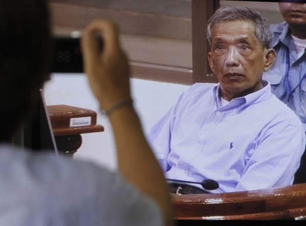 A television screen showing Kaing Guek Eav, also known as Duch, who ran the Khmer Rouge’s Tuol Sleng detention center, is the focus Monday for a photographer at the press center of the U.N.-backed war crimes tribunal in Phnom Penh, Monday.