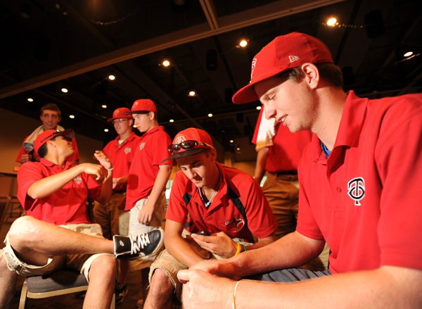Dane Gordon, right, and Anthony Buonaiuto, both 17-year-old pitchers for Team Ontario, play games on their smart phones during a dinner for players and coaches taking part in this week’s Premier Baseball National Sophomore Championship on Tuesday at the Fayetteville Town Center.