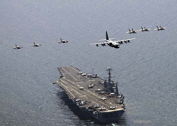 A U.S. Marine Corps C-130 Hercules aircraft leads a formation of F/A-18C Hornet strike fighters and A/V-8B Harrier jets Tuesday over the aircraft carrier USS George Washington in the East Sea off the Korean peninsula in this photo released by the U.S. Navy.