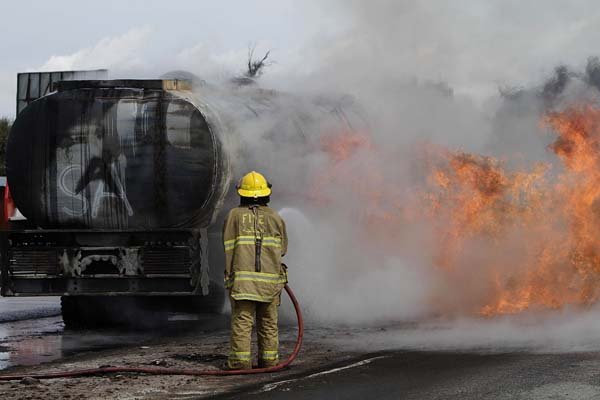 An Afghan fireman works to extinguish a burning oil tanker after an explosive device planted underneath it exploded, near a NATO air base in Jalalabad, east of Kabul, on Thursday.