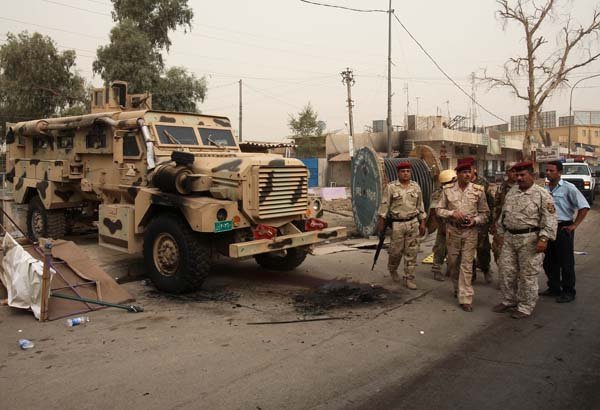 Iraqi security forces inspect the scene of an attack on their checkpoint in Baghdad on Thursday.