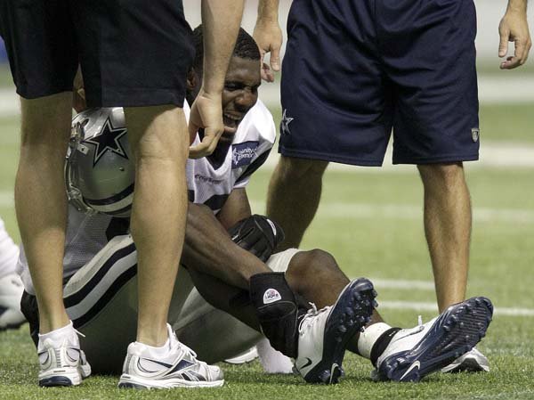 Trainers assist Dallas Cowboys wide receiver Dez Bryant after he got tangled up with cornerback Orlando Scandrick during practice Friday. Bryant will be out 4-6 weeks after suffering a high ankle sprain.