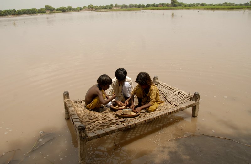 Pakistani children sit on a bed to eat their food, in a flood hit area of Qasim Bella, on the outskirts of Multan, Pakistan, on Saturday, July 31, 2010. The death toll in the massive flooding in Pakistan surged past 800 as floodwaters receded Saturday in the hard-hit northwest, an official said. 