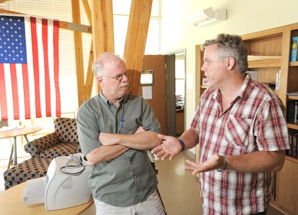 Mark Horvath, founder of Invisible People.tv, right, and Kevin Fitzpatrick, local homelessness advocate and University of Arkansas professor, speak Friday at the Seven Hills Homeless Center in Fayetteville.
