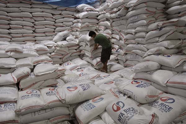 A man moves bags of rice Friday in a government warehouse in Quezon City, Philippines.