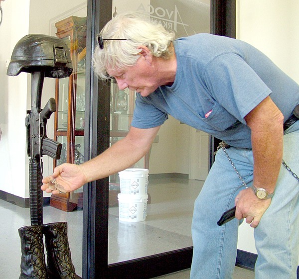 James Bailey, an Army veteran who served in Vietnam, looks at the blank name tags hanging from the Battlefield Cross sculpture to be placed on a marble base on the Veterans’ Memorial in front of the Avoca City Hall.