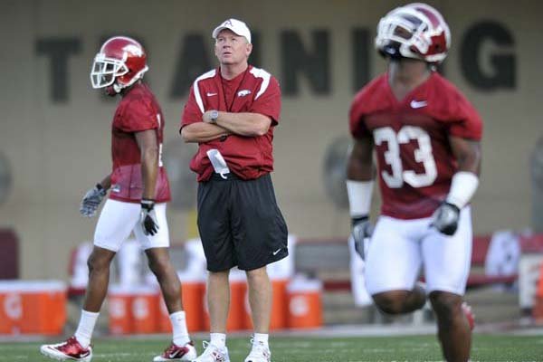 Arkansas Coach Bobby Petrino watches Dennis Johnson (33) during early drills in the Razorbacks’ first practice Thursday in Fayetteville.