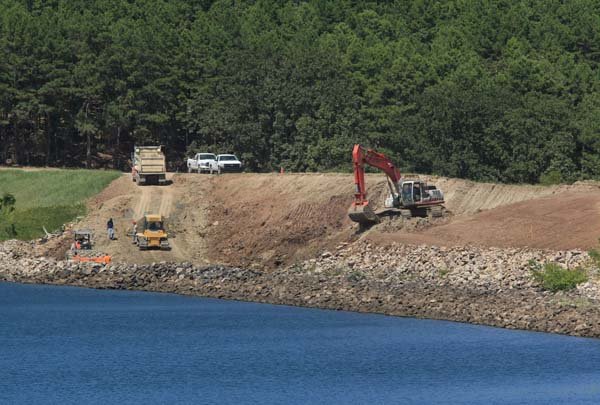 Construction crews repair an eroded portion of the dam Monday afternoon at Lake Maumelle. The lake has been drawn down several feet to facilitate the dam repair.