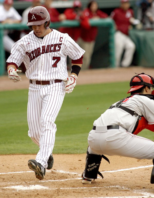 Arkansas’ Zack Cox crosses home plate ahead of the throw home to Georgia catcher Christian Glisson in the first inning April 17 in Baum Stadium in Fayetteville.