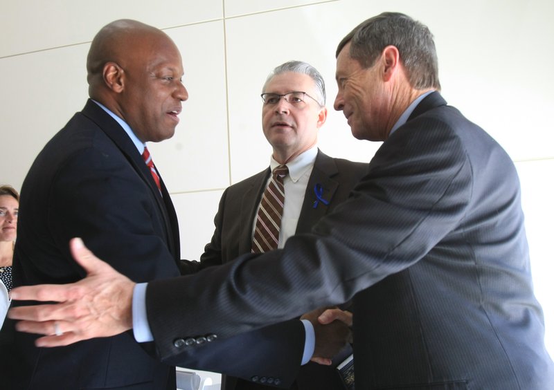 Rick Wade (left), deputy chief of staff at the U.S. Department of Commerce, shakes hands with Dr. Curtis Lowery (middle), chairman of Obstetrics and Gynecology in the UAMS College of Medicine, and Morril Harriman, Gov. Beebe's chief of staff, following the announcement of a $102 million grant to expand broadband Internet access in the state Wednesday in Little Rock.	 