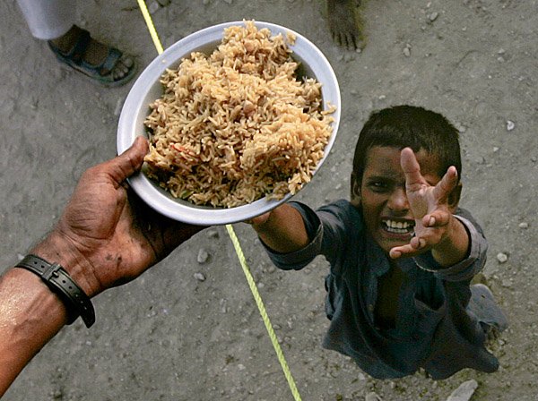  A boy receives relief food at a camp for flood affected people on the outskirt of Sukkur, in southern Pakistan.