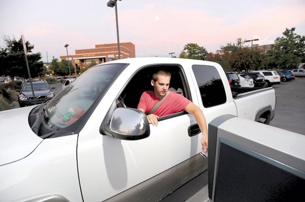 Daniel Wolf, a University of Arkansas student from Conway, prepares to pay for parking Saturday at a kiosk at the northern end of the Walton Arts Center parking lot on West Dickson Street after visiting the entertainment district in Fayetteville.