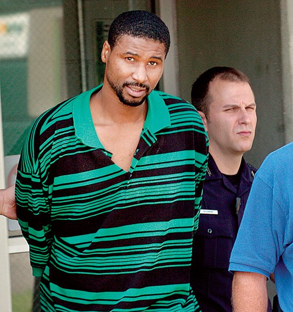 Trimell McIntosh is seen after he was arrested Monday in the 1995 shooting death of Larry "Lunch Meat" Robinson on S. Wolfe St., is taken to jail by Little Rock police officers.