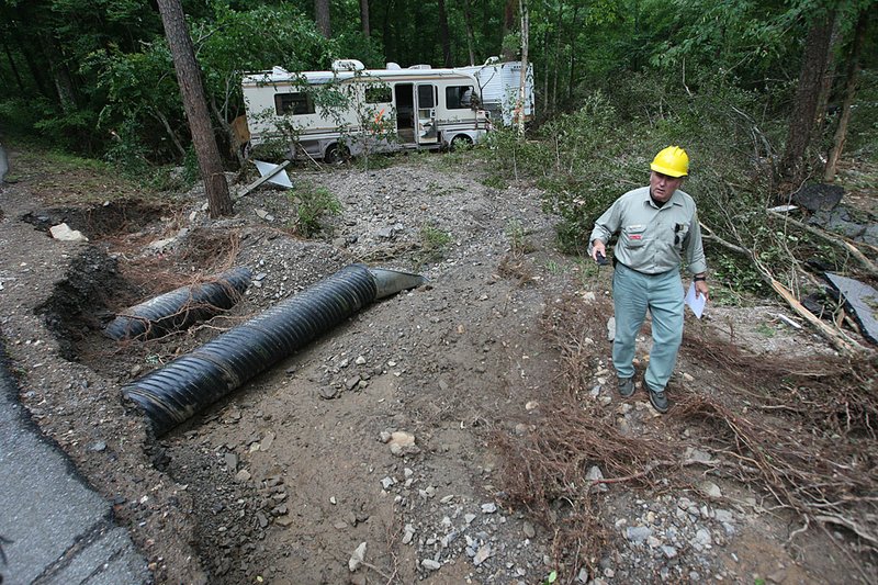 This June 12, 2010 file photo shows John Nichols with the US Forest Service climbs away from debris at the Albert Pike Campground in Montgomery County.