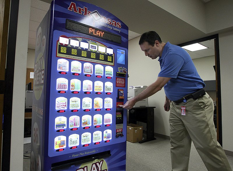 Information technology gaming director Mike Smith demonstrates the lottery vending machine at lottery headquarters in Little Rock on Thursday.