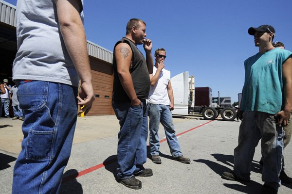 Josh Johnson, from left, Koyle Olsen, and Anthony Hunt, take a smoke break Wednesday outside of their diesel mechanics class at Northwest Technical Institute in Springdale. The school still allows students to smoke as long as they are 25 feet from building entrances.
