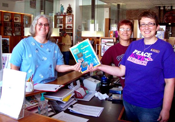 Sheila Hart, left, receives a book of her choice after winning the drawing from names of survey participants. She is pictured with Angela Nelson and Holly Hill. While visiting the library, Hart, the daughter of library volunteer Lenora McClary, filled out the library survey and entered the drawing for a free book of her choice. Her name was drawn and she chose the book The Amphibians and Reptiles of Arkansas because she has been finding copperhead snakes in her yard and she wanted to learn more about them. Hart has lived in Gentry all her life and for the past seven years has worked at Gentry Primary School cafeteria. During her summer breaks she is often here on Monday morning to visit with her mother and to offer her assistance when needed.
