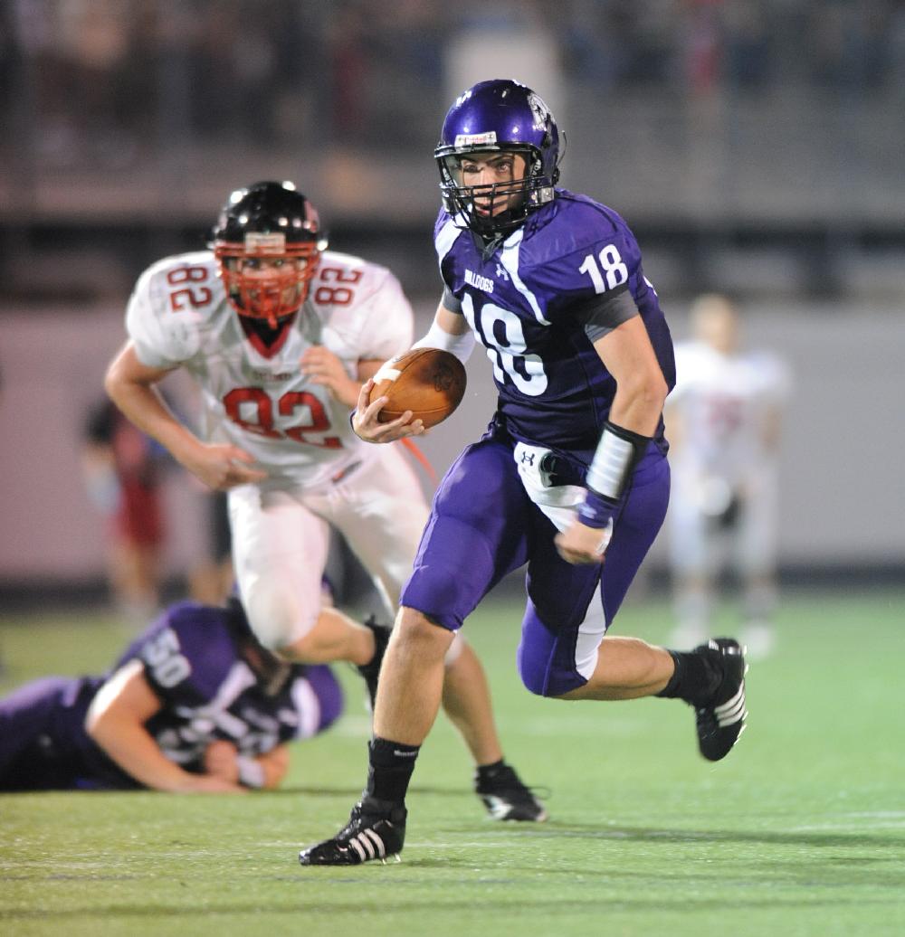 ANDY SHUPE Northwest Arkansas TimesFayetteville junior quarterback Brandon Allen carries the ball through the Russellville defense during the Dogs' and Cyclones' 26-26 tie Friday at Harmon Field.