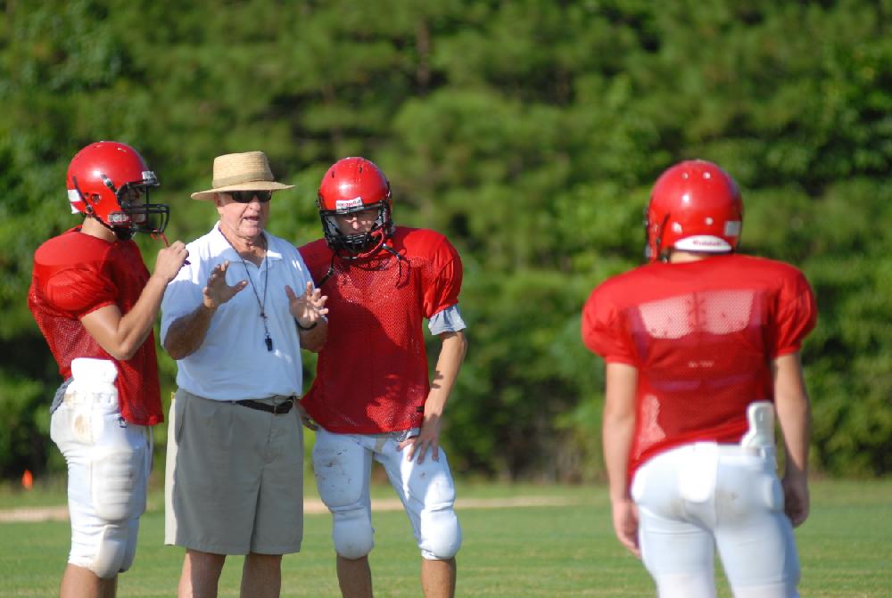 Harmony Grove head football coach Red Parker works on the punt return with players.