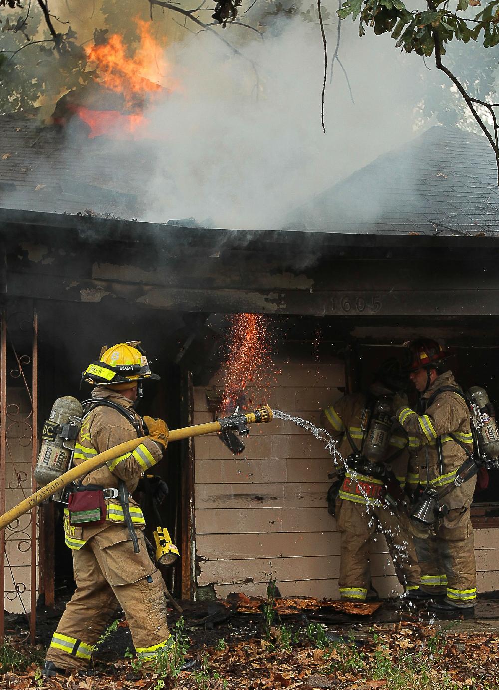 Arkansas Democrat-GazetteBENJAMIN KRAIN --9210--
Little Rock firefighters Ryan Baker, left, Doug Coffman CQ and Jackie Rankin battle a fire at a vacant house on 16th and Elm St in Little Rock on Thursday afternoon.