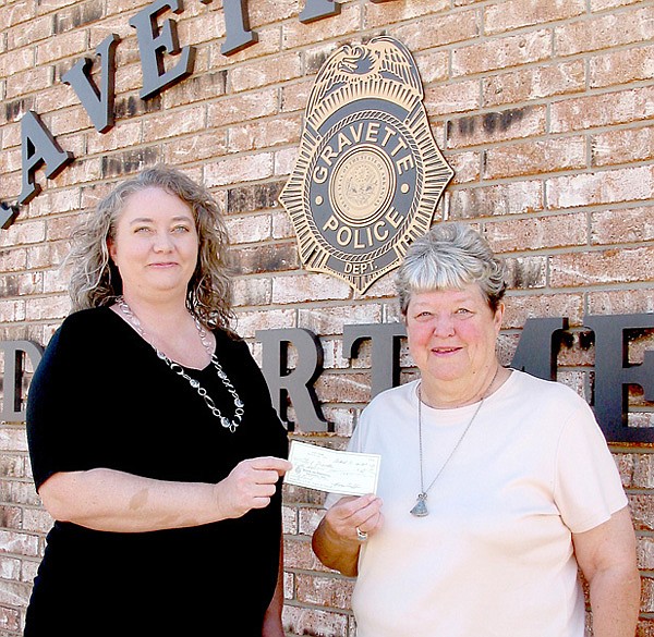 Pennie Barry who oversees the adoption process for pets at the Gravette Animal Shelter, receives a check from the Jolly Good Times Club to help with operation of the shelter. A fund drive is underway to secure a heating system for the facility.