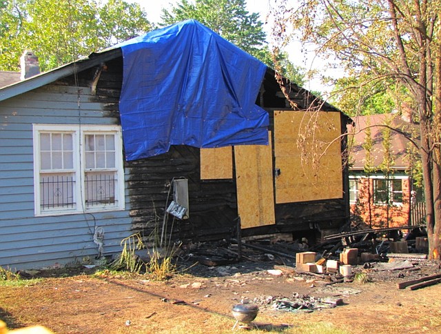 Boards and a tarp help cover damage to a Hillcrest home damaged in a fire early Wednesday morning.