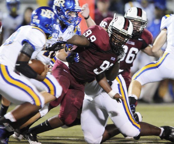 Springdale High’s Michael Wright looks to tackle North Little Rock’s Kendall Williams in the first half Friday in Jarrell Williams Bulldog Stadium in Springdale.

