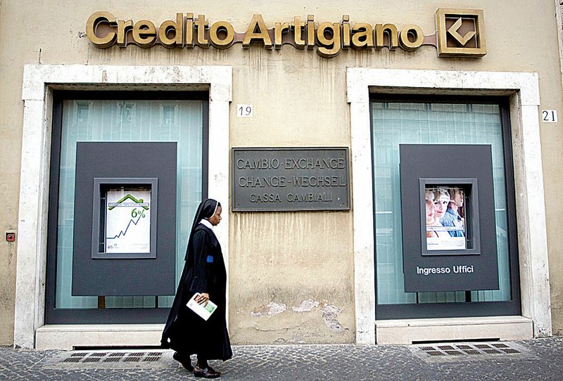 A nun passes a Rome branch of Credito Artigiano, the northern Italy-based bank at which activity on an account held by the Vatican raised suspicions of banking officials.