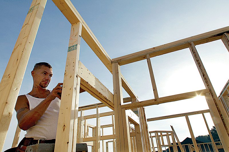 Construction worker Randy Shreves works on the frame of a new house in Springfield, Ill., last week. Construction of new homes rose last month, the Commerce Department said Tuesday.