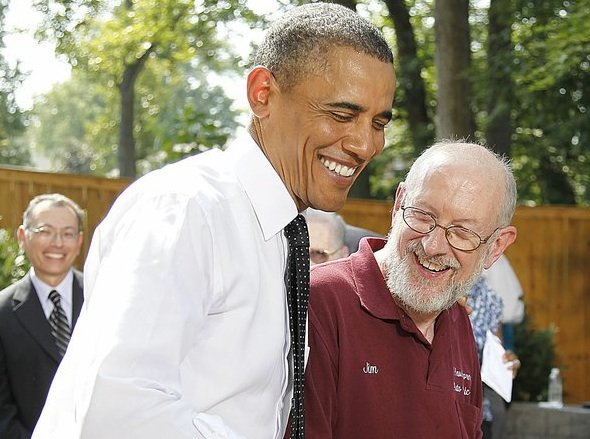 President Barack Obama visits with auto-repair-shop owner Jim Houser of Portland, Ore., after a discussion of this year’s health-care law Wednesday in Falls Church, Va.