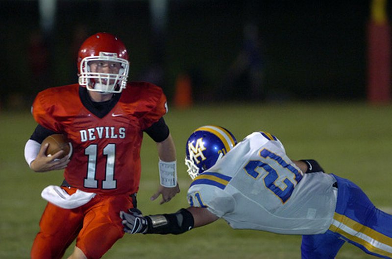 Jacksonville quarterback Logan Perry (11) gets past Mountain Home’s Cole Barrow (21) during Thursday’s game in Jacksonville. Perry completed 13 of 19 passes for 217 yards. 