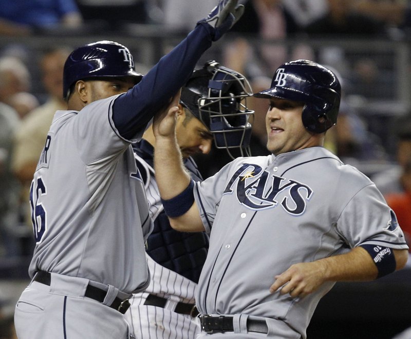 Tampa Bay’s Willy Aybar (left) and Kelly Shoppach celebrate after scoring on B.J. Upton’s seventh-inning double in the Rays’ 10-3 victory over the New York Yankees. 