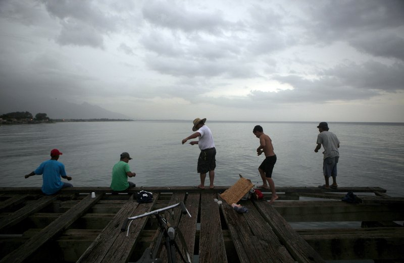 Men fish before heavy rain in La Ceiba, Honduras, Friday, Sept. 24, 2010. According to the U.S. National Hurricane Center, tropical storm Matthew's drenched the Caribbean coast and threatened much of northern Central America prone to disastrous flooding. 