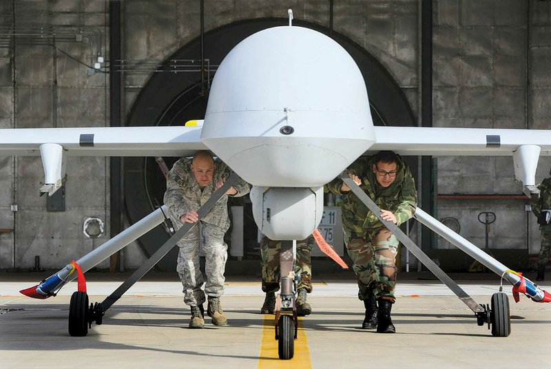 A California National Guard ground crew pushes a Predator drone from its hangar at the former George Air Force Base in Victorville, Calif., earlier this year.
