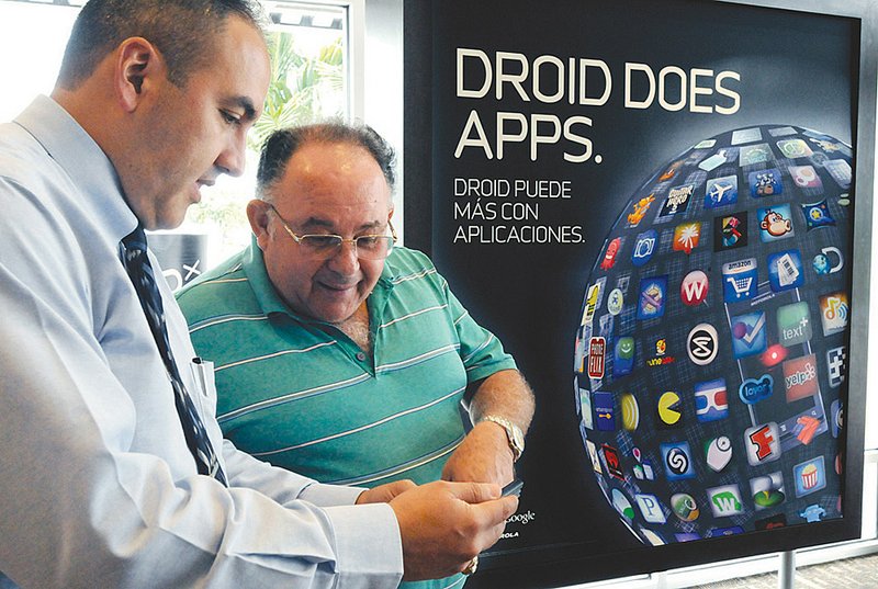 Christian Agila, manager of a Verizon Wireless store in Hialeah, Fla., shows Daniel Motola the newest Android smart phone, the Samsung Fascinate, earlier this month.