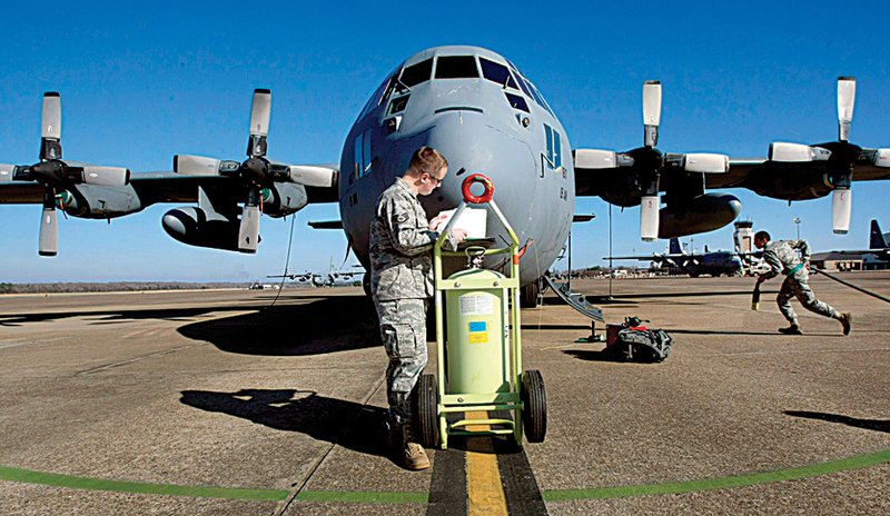Staff Sgt. Tom Patterson (left) looks over paper work as Airman First Class Kelly Sanchez hooks up a generator to "Patches", a C-130 bound for the bone yard. The plane, built in 1962, has seen heavy combat in Vietnam, Grenada, the Gulf War and Iraq.