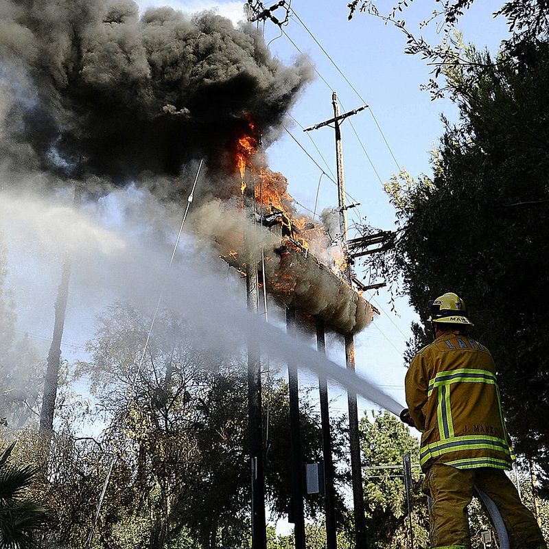 A Los Angeles firefighter battles a fire caused by a transformer that overheated and exploded.