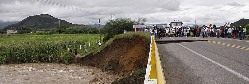 Traffic is halted Tuesday at a damaged bridge leading to Santa Maria de Tlahuitoltepec in Mexico’s Oaxaca state, hampering efforts to assist mudslide victims.