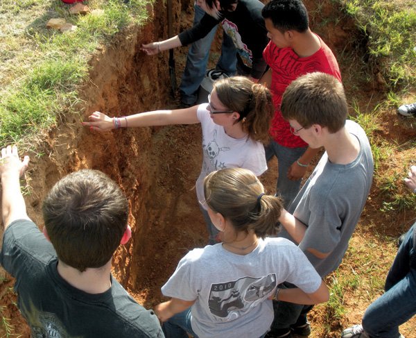 Decatur students Nicole Buckmaster, Josh Hare, Lensey Watson and Sean Wilson identified soil horizons during one of the handson sessions on Wednesday at the University of Arkansas Agricultural Research Station in Fayetteville. 
