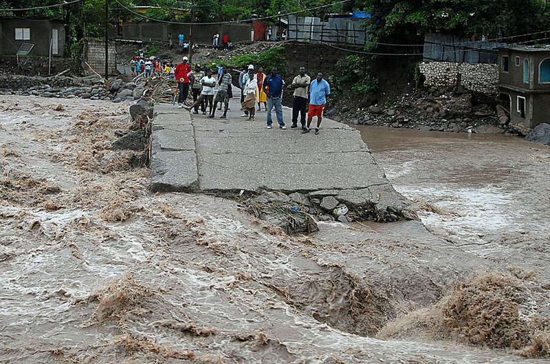 Floodwaters from Tropical Storm Nicole surge past a destroyed bridge that linked the Jamaican towns of Kintyre and Kingston on Wednesday.