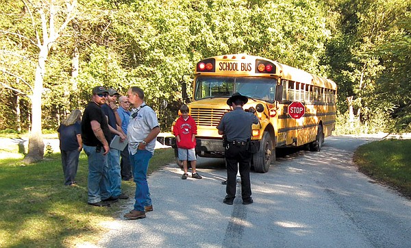  Firefighters Josh Greer and Danny Miller, Decatur School's transportation manager Sherman Robinson and fire chief David Flynt looked on while a Benton County Deputy Sheriff took a report on the accident.
