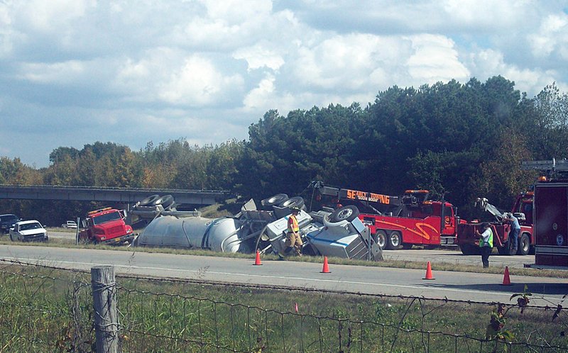 A tow truck pulls a tractor trailer out of the grass on Highway 67/167 near Searcy on Tuesday.