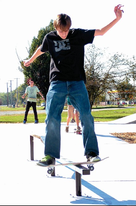 Garrett Blaine tries out a grind bar at the new skate spot skate park in Gentry last Wednesday. As soon as the barricades came down, the skateboarders were there testing their skills in the new facility. 