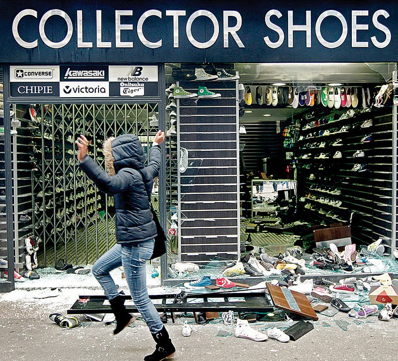 Shoes and glass lie scattered around a looted shop in Lyon, France, on Tuesday during a violent demonstration over plans to raise the country’s retirement age. 