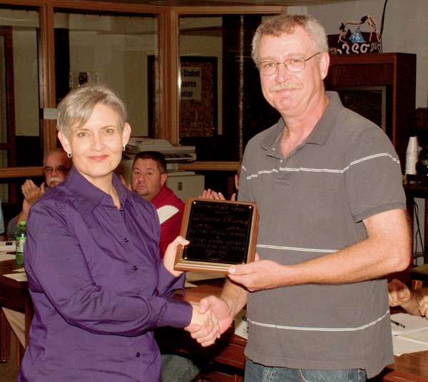 Dianne Burrus receives a Teacher of the Year Award from school board chairman Jim Barnes on Monday night at the high school library.
