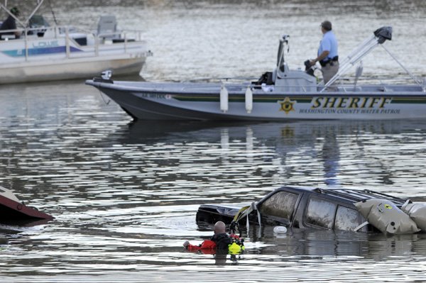 A member of the Washington County Dive Team keeps an eye on a GMC Jimmy belonging to Kelly Lockhart as it is pulled from Beaver Lake Oct. 15 near the U.S. 412 bridge east of Springdale.
