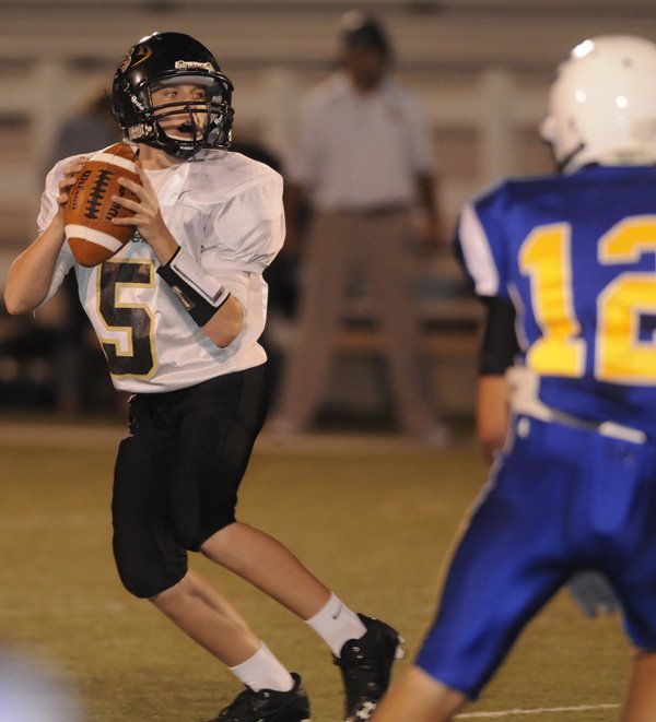 Bentonville Black quarterback Jacob Sisson looks for an open receiver Thursday against Springdale Central in Jarrell Williams Bulldog Stadium in Springdale.