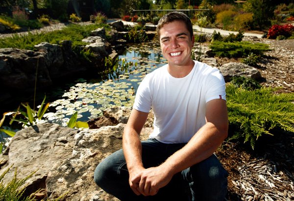 Seth Fleming, lead gardener at the Botanical Garden of the Ozarks, loves to work in the garden’s koi pond.