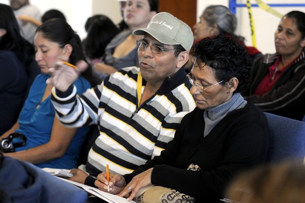 Ines Melgar-Hernandez, left, asks questions Oct. 16 as his wife, Olimpia Melgar, takes notes during a legal clinic at the Family Resource Center in Springdale. Attorneys were on hand to answer questions about U.S. citizenship.
